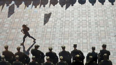 A girl walks by policemen on guard during a protest in Kiev. Genya Savilov / AFP Photo