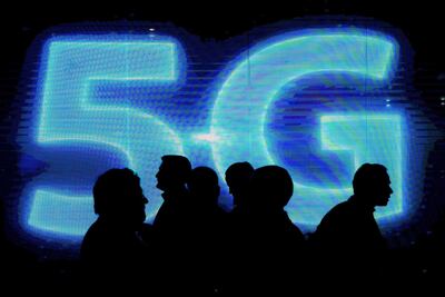 Visitors walk past a 5G logo during the Mobile World Congress on the third day of the MWC in Barcelona, on March 1, 2017. AFP