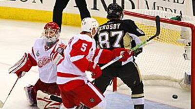 Goaltender Chris Osgood of the Detroit Red Wings reacts as teammate Nicklas Lidstrom and Sidney Crosby of the Pittsburgh Penguins watch the go-ahead goal scored by Sergei Gonchar.