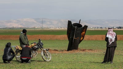 People stand next a missile after it fell near Qamishli International Airport, amid the U. S. -Israeli conflict with Iran, in Qamishli, Syria, 4 March 2026. REUTERS / Orhan Qereman TPX IMAGES OF THE DAY REFILE – REMOVING ATTRIBUTION OF THE MISSILE