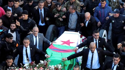 People walk next to the coffin of Lt Gen Ahmed Gaid Salah in Algiers, Algeria. EPA