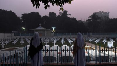 Bangladeshi nuns offer prayers at a cemetery prior to a mass at the Holy Rosary church in Dhaka. Prakash Singh / AFP Photo
