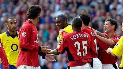 Former Arsenal player Patrick Vieira, centre, is restrained by Manchester United players to keep him away from Ruud van Nistelrooy, second from left, after an altercation between them lead to Viera's ejection at Old Trafford, in Manchester, on September 21, 2003. AFP Photo Paul Barker