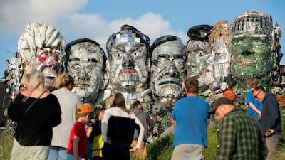 People look at artwork called Mount Recyclemore: The E7, which has been created out of e-waste, in the likeness of the G7 leaders and in the style of Mount Rushmore by British artist Joe Rush on Sandy Acres Beach in Cornwall. AP Photo