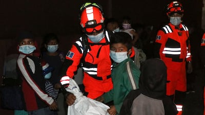 Handout picture released by Bomberos Volutarios shows Firefighters help evacuees settle in a temporary shelter in Santa Lucia Cotzumalguapa south Guatemala City. Some 370 people from a community based at the base of the Fuego volcano, in southwestern Guatemala, were evacuated on Monday following the increase in the volcanic activity of the colossus, the Civil Protection Agency reported. AFP