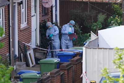 Police officers in forensic suits enter a house in Bermondsey where four people were fatally stabbed. PA.