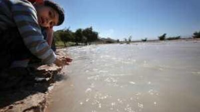 Children play with water that floods into the Wadi Shuaib dam near south Shuneh.