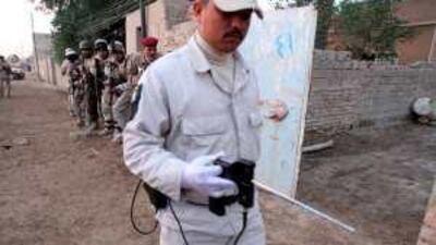 A security personnel searches for explosives with the an ADE-651 as soldiers prepare to storm a suspected al Qa'eda hideout near Karbala.
