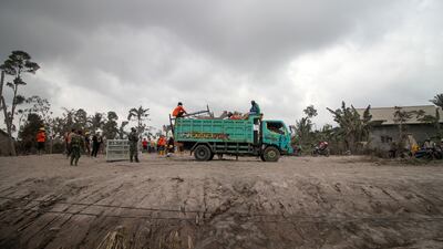 Villagers load their belongings on to a truck as they leave their houses. EPA