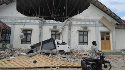 A man rides past a district hospital which was damaged after the earthquake in Pidie Jaya, Aceh province on December 7, 2016. At least 52 people were killed and hundreds injured on December 7 after a strong earthquake struck Indonesia’s Aceh province, with officials warning the death toll would likely rise. Chaideer Mahyuddin / AFP