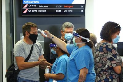 Passengers arriving from Brisbane are temperature checked on arrival at Perth Airport in Australia. Paul Kane / Getty