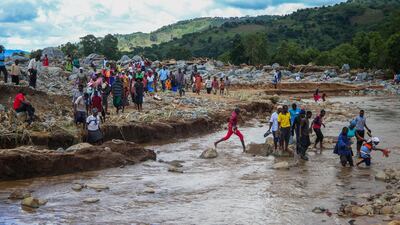 People cross a stream in an area flooded by Cyclone Idai in Chipinge, Zimbabwe. Getty Images