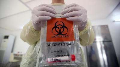 A member of medical staff carries a swab test at a drive-thru testing facility at Bahrain Exhibition Center, in Manama, Bahrain. Reuters