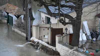 A barrier erected in front of a house to block floodwater from the Seine river, left, in Bougival, west of Paris. Stephane De Sakutin / AFP