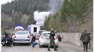 Police and security officers take cover after an attack on a police escort in northern Turkey. Suspected separatist militants threw an explosive device and opened fire on a police escort, killing one officer.