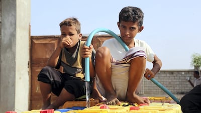 Yemeni children fill jerrycans with water in an impoverished coastal village on the outskirts of the rebel-held port city of Hodeidah on October 18, 2016. AFP