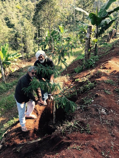 Mohammed Ahmed Ibrahim and Vivek Vilasini (right) plant an Indian gooseberry tree in honour of Hassan Sharif, Munnar, India, 16 December 2016.