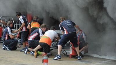 Racing team crews try to extinguish a fire in the Williams racing pit stand at the Circuit de Catalunya yesterday. Josep Lago / AFP
