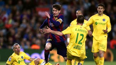 Barcelona's Lionel Messi, centre, vies with Getafe defender Alvaro Arroyo during their Primera League match at the Camp Nou in Barcelona on April 28, 2015. AFP PHOTO/ LLUIS GENE