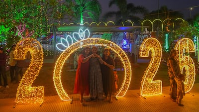 Revellers pose for a picture near illuminated decorations in Mumbai, India. AP