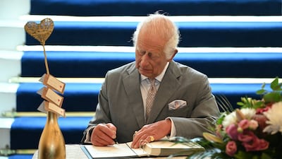The king signs a book of condolence during his visit to Southport Town Hall. Getty Images