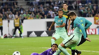 Barcelona’s Gerard Pique, right, scores his side’s second goal during the Champions League match against Borussia Monchengladbach. Martin Meissner / AP Photo