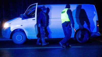 A police officer checks a vehicle entering the state-of-emergency area at a checkpoint near the village of Narew, eastern Poland. AFP