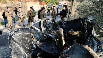 Lebanese troops guard a car hit by an Israeli drone strike in Aatqanit, southern Lebanon, on Monday. EPA