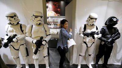 A store staff walks past other staffs dressed up as Stormtrooper and Death Star Gunner right. Toru Hanai / Reuters