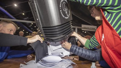 Ballot cards are poured onto a table for counting at the Titanic centre. PA
