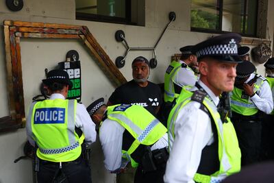 Police detain a protester wearing a T-shirt in support of Irish rap group Kneecap. He denied a handmade banner had mentioned Palestine Action. Reuters
