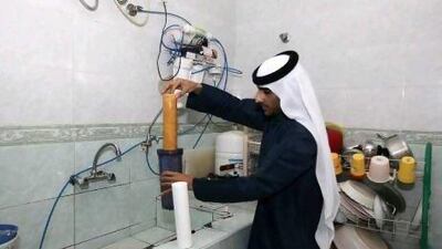 Ahmad Jumah changes the old cartridge in the water filter which is installed in the kitchen at his home in Al Munai village in Ras Al Khaimah.