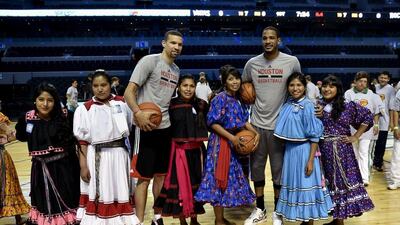 Francisco Garcia, left, and Trevor Ariza, right, of the Houston Rockets pose for a photo with players from the Tarahumara women's basketball team during an NBA clinic in Mexico City on Tuesday. Yuri Cortez / AFP
