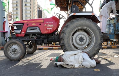 A farmer sleeps near a tractor after he was stopped by police at the Delhi Gazipur Border.