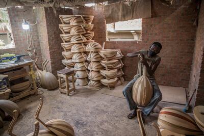 A man works on Arabian ouds at a workshop belonging to Khaled Azzouz, a veteran oud-maker at the al-Marg district on the outskirts of the Egyptian capital Cairo in October 2020. AFP