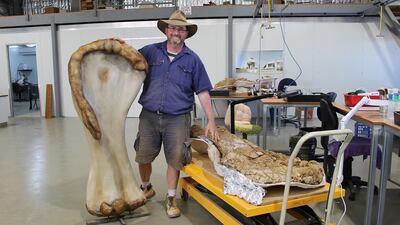 Dr Scott Hocknull poses with a 3D reconstruction and the humerus bone of "Cooper," a new species of dinosaur discovered in Queensland and recognised as the largest found in Australia. Eromanga Natural History Museum / Reuters