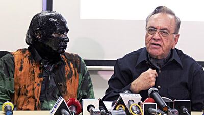 Sudheendra Kulkarni, left, whose face was blackened by ink in an alleged attack, looks on as Khurshid Mahmud Kasuri, the former Pakistani foreign minister, speaks to media in Mumbai on October 12, 2015. Mr Kulkarni said he was assaulted as he left his home in Mumbai. AFP Photo