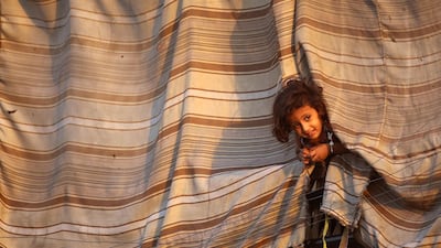 A displaced Syrian child, who fled ISIL's Syrian stronghold of Raqqa as fighters from a US-backed coalition battle to retake the city, stands at an abandoned house where people take refuge in the town of Tabqa on September 6, 2017. Delil souleiman / AFP