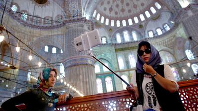 A South Korean tourist (right) takes a selfie as she visits the Ottoman-era Sultanahmet mosque, also known as the Blue Mosque, in Istanbul. Murad Sezer / Reuters