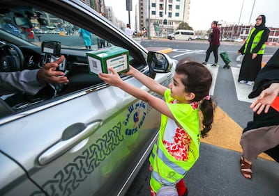Volunteers from Beit Al Khair Society and Al Ihsan Charity Association distribute food packages for iftar as the day nears sunset in Abu Dhabi. Victor Besa / The National