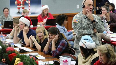 NORAD Chief of Staff Maj. Gen. Charles D. Luckey takes a call while volunteering at the NORAD Tracks Santa center at Peterson Air Force Base in Colorado Springs. AP