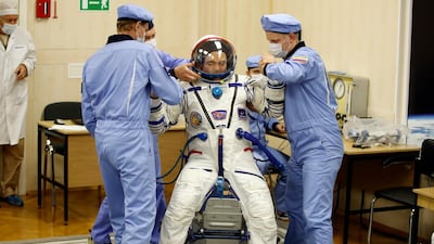 Russian Space Agency experts help Russian cosmonaut Oleg Skripochka stand up after inspecting his space suit. Dmitri Lovetsky / AP