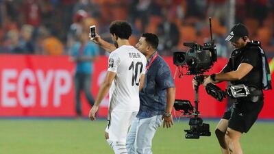 Egypt's Mohamed Salah poses for a selfie with a fan after the match. Reuters