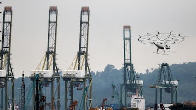 A Volocopter air taxi flies past a building during its test flight in Singapore. The Volocopter is a manned, electric powered multicopter. EPA