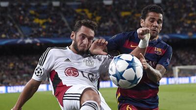 Bayer Leverkusen's Hakan Calhanoglu vies for the ball with Barcelona's Dani Alves during their Champions League contest on Tuesday at the Camp Nou. Josep Lago / AFP