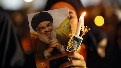 A Hezbollah supporter carries pictures of the group's former leader Hassan Nasrallah in Beirut on Friday. EPA