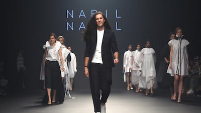Nabil Nayal, walking the runway above at Fashion Forward in Dubai in 2017, has not been back to his Syrian birthplace in decades, but is returning to his roots via the country's rich textiles. Getty Images