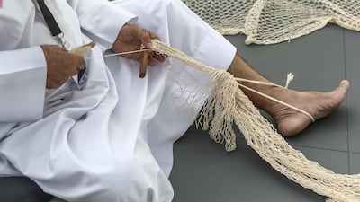 An Emirati weaves fishing nets. Antonie Robertson/The National