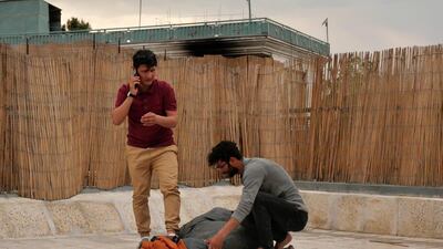 Zabih Afzali and his friend wrap up a sleeping bag together on the roof terrace of an office in Kabul as they prepare for a mountain expedition in Bamiyan over the Eid holiday. Charlie Faulkner for The National