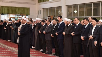A picture released by Syria’s official news agency Sana showing Syrian president Bashar Al Assad, centre, peforming the morning prayer of the Muslim holiday of Eid Al Adha at the Al Adel mosque in Damascus on September 24, 2015, in a rare public appearance for the embattled regime head. AFP Photo / HO / Sana